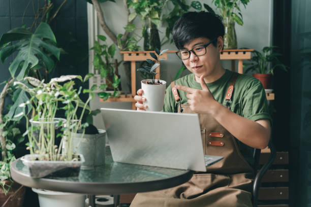 a man with glasses in a green shirt working with his laptop on a coffee shop